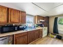 Cozy kitchen featuring wooden cabinets, a laminate countertop, a double-basin sink, and views from the window at 105 E Cole St, Dunn, NC 28334