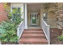 Inviting front porch with brick steps, white railings, and a storm door at 11035 Southwalk Ln, Raleigh, NC 27614