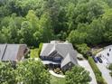This aerial shot shows a beautiful home surrounded by lush trees, offering privacy and a serene setting at 112 Roseberry Way, Holly Springs, NC 27540