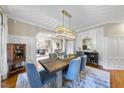 Elegant dining room featuring paneled walls, a modern chandelier, and stylish decor at 112 Roseberry Way, Holly Springs, NC 27540