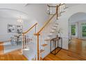 Bright foyer with hardwood floors and stairs, leading to a dining room with a chandelier at 113 Wilander Dr, Cary, NC 27511