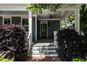 Inviting front porch with ceiling fan, steps, and classic columns, enhanced by lush greenery at 1313 Dale St, Raleigh, NC 27605