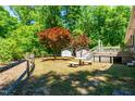 Expansive backyard featuring mature trees, well-maintained lawn, sheds, and a wooden deck, perfect for outdoor living at 2100 Fort Dr, Clayton, NC 27520