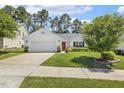 Charming one-story home boasts an attached garage and a well-manicured lawn at 217 Braxcarr St, Holly Springs, NC 27540