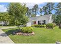 View of a quaint one-story home with a manicured lawn at 217 Braxcarr St, Holly Springs, NC 27540