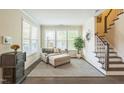 Inviting living room with plush seating, abundant natural light, and staircase access at 221 Mayfield Dr, Apex, NC 27539