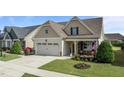Charming single-Gathering home featuring a two-car garage, covered porch, and beautifully landscaped front yard at 24 Sweet Birch Row, Youngsville, NC 27596
