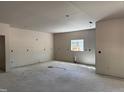 Bright living room featuring unfinished drywall, concrete floor, and a window for natural light at 240 Green Pines Estates Dr, Kenly, NC 27542