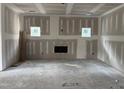Large, open living room with fireplace feature and plenty of natural light from the two windows at 240 Green Pines Estates Dr, Kenly, NC 27542