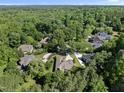Expansive aerial view of a neighborhood with lush trees and well-maintained homes, showcasing a serene, wooded community at 313 Helmsdale Dr, Chapel Hill, NC 27517