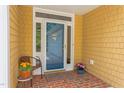 Inviting front porch with brick flooring, a chair with colorful flowers, and a screen door providing a warm welcome at 313 Helmsdale Dr, Chapel Hill, NC 27517