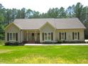Charming one-story home with manicured front lawn and mature trees at 3653 Range Rd, Stem, NC 27581