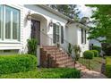 Close-up of the front entrance with brick steps, iron railing, and elegant sconces at 4830 North Hills, Raleigh, NC 27612