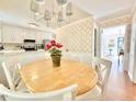 Cozy dining area features a light wood table, white chairs and a view into the kitchen at 5021 Lansdowne Dr, Durham, NC 27712