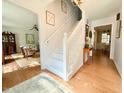 Bright entryway with a white staircase, hardwood floors, and a view into the living room at 5021 Lansdowne Dr, Durham, NC 27712