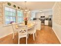 Bright kitchen with white cabinets, stainless steel appliances, and a sunny window overlooking the yard at 5021 Lansdowne Dr, Durham, NC 27712