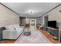 Bright living room with hardwood floors, gray trim, modern lighting, and comfortable seating near a brick fireplace at 603 Gentry Ln, Hillsborough, NC 27278