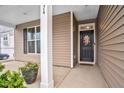 Inviting front porch featuring decorative wreath, dark door and concrete flooring at 74 Hidden Grove Ct, Garner, NC 27529