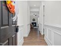 Hallway leading to the living area with hardwood floors and white decorative molding at 74 Hidden Grove Ct, Garner, NC 27529