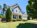 Inviting home with lush lawn, showcasing architectural details and a welcoming two-car garage at 112 Victorian Oaks Dr, Durham, NC 27713