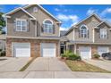 Two-story townhome exterior featuring stone accents, a two car garage, and neutral color siding at 114 Montview Way, Knightdale, NC 27545