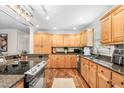 Well-lit kitchen featuring wooden cabinets, granite countertops, and modern stainless-steel appliances at 1199 Cesar Ct, Graham, NC 27253