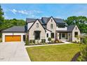 Beautiful two-story home with a manicured lawn and a three-car garage in daytime at 1209 Briar Patch Ln, Raleigh, NC 27615