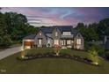 Exterior view of a two-story home at dusk showing stone and painted brick exterior at 1209 Briar Patch Ln, Raleigh, NC 27615