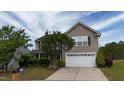Traditional two-story home with an attached two-car garage, mature trees, and lush landscaping at 126 Thimbleweed Ln, Lillington, NC 27546