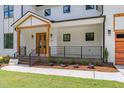 Inviting front porch with wood columns, black railings, and double doors leading into the home at 1301 Doylin Dr, Cary, NC 27511
