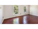 Empty room showcasing hardwood floors and two large windows at 1324 Swallow Dr, Raleigh, NC 27606