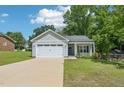 Inviting home featuring an attached garage, well-kept lawn, and a charming covered entryway at 15 Nottingham Pl, Smithfield, NC 27577