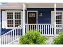 Inviting front porch with a dark-stained front door and white railing at 1508 Malta Ave, Raleigh, NC 27610