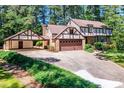 Charming two-story home with brick and Tudor-style accents, a covered carport, and a large driveway at 1604 Westbridge Ct, Raleigh, NC 27606