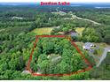 Aerial view of the expansive property line shows a wooded area, a home, and proximity to Jordan Lake at 168 E Deer, Apex, NC 27523