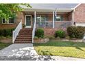 Close up of the inviting brick front porch with white railings and well-maintained landscaping at 1732 Bobwhite Ln, Rocky Mount, NC 27804