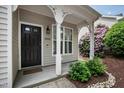 Inviting front porch featuring decorative trim, a dark front door, and lush landscaping at 1910 Falls Landing Dr, Raleigh, NC 27614