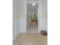 Inviting entrance hallway with light hardwood floors and classic white wainscoting detail at 1913 Ballard Rd # 193, Fuquay Varina, NC 27526