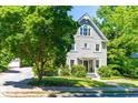 Inviting two-story home with a gabled roof, showcasing classic architecture and mature trees in the front yard at 2111 Woodland Ave, Raleigh, NC 27608