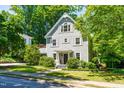 Beautiful two-story home with light gray siding, complemented by lush greenery and a neatly manicured lawn at 2111 Woodland Ave, Raleigh, NC 27608