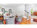 Bright living room featuring hardwood floors, neutral-toned furniture, and staircase access to upper floor at 2111 Woodland Ave, Raleigh, NC 27608