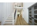 Bright entryway with tall ceilings, staircase, wood floors, and stylish glass paneled doors at 2200 Mays Crossroads Rd, Louisburg, NC 27549