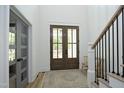 Inviting foyer with a wood-framed glass front door, wood floors, and a staircase to the side at 2200 Mays Crossroads Rd, Louisburg, NC 27549
