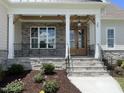 Inviting front porch with stone pillars, wood accents, and a charming entrance at 25 Deer Tail Ln # 52, Fuquay Varina, NC 27526
