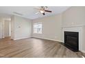 Bright living room with a cozy fireplace, ceiling fan, and wood-look flooring throughout at 2513 Magnolia Tree Ln, Durham, NC 27703