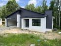 Contemporary home boasts dark siding, white brick, a metal roof, and an attached two-car garage at 269 Deer Tail Ln # 44, Fuquay Varina, NC 27526