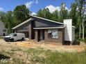 Exterior view of modern new construction home with a brick and gray board and batten exterior at 269 Deer Tail Ln # 44, Fuquay Varina, NC 27526