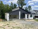 Modern home with a black metal roof, white brick accents, and large windows offering natural light at 269 Deer Tail Ln # 44, Fuquay Varina, NC 27526