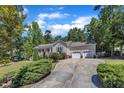 Lovely single-story house with a two-car garage and a spacious driveway surrounded by lush greenery at 345 Kinsman Ct, Fuquay Varina, NC 27526