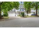 Two-story home with a two car garage, blue shutters, front porch, and driveway on a tree lined street at 429 Marsh Landing Dr, Holly Springs, NC 27540
